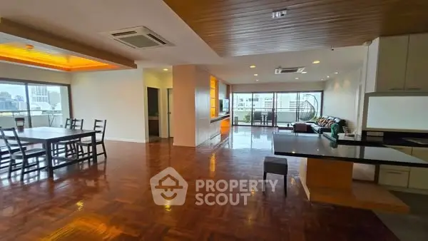 Spacious open-plan living and dining area with wooden flooring and city view.