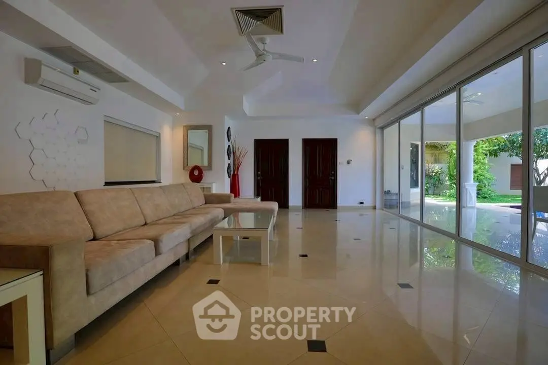 Spacious living room with modern decor and large windows overlooking garden