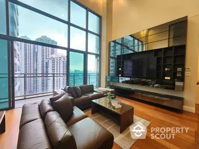 Luxurious high-rise living room with floor-to-ceiling windows offering a panoramic city view, complemented by a sleek entertainment unit and plush leather sofa.