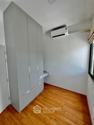 Modern minimalist bedroom with sleek wardrobe and air conditioning