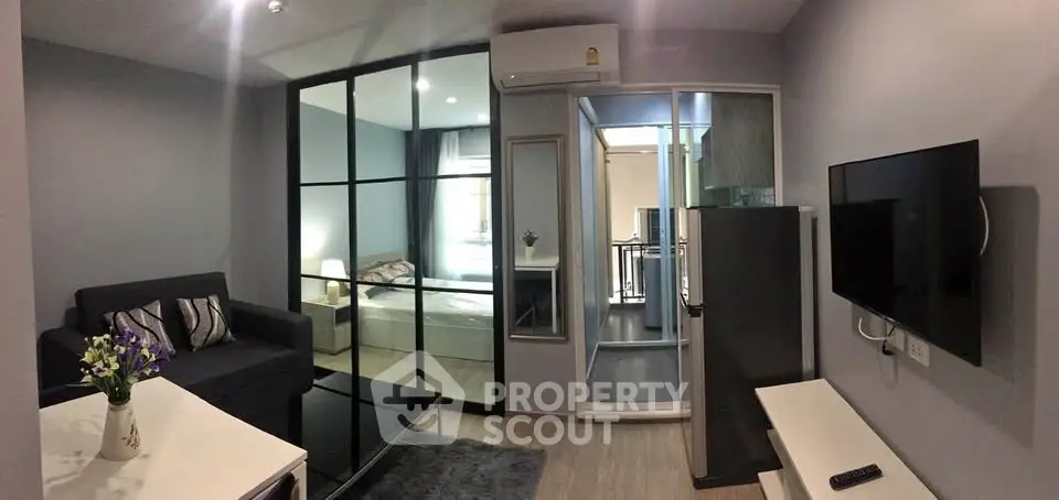 Modern living room with sleek design and glass partition to bedroom