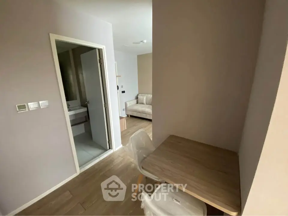 Cozy apartment interior with study area and partial bathroom view, ideal for modern living.