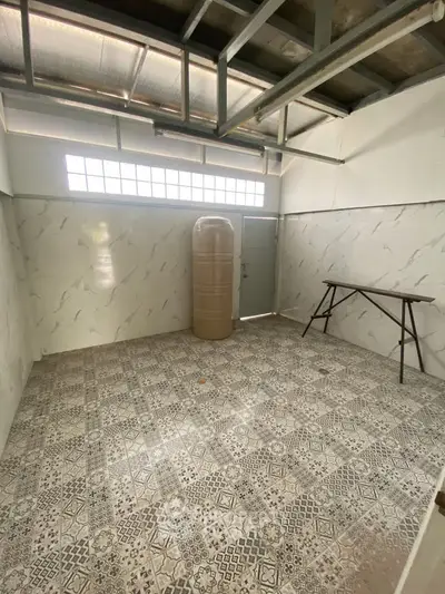 Spacious storage room with patterned tile flooring and ample natural light.