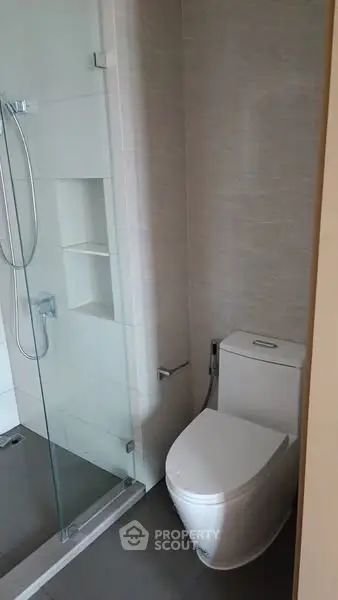 Modern bathroom with sleek shower and toilet in contemporary design.