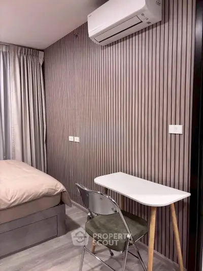 Modern bedroom with stylish wood paneling and compact study area