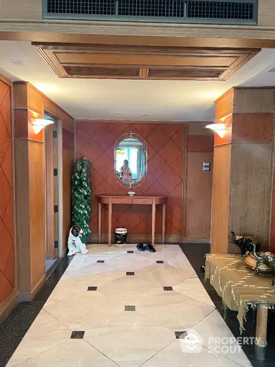 Elegant entrance hall with wooden paneling and decorative mirror