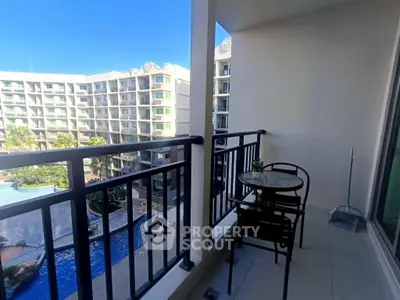 Spacious balcony with pool view in modern apartment complex