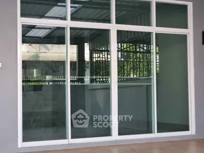 Modern glass sliding doors leading to a bright interior space with tiled flooring.