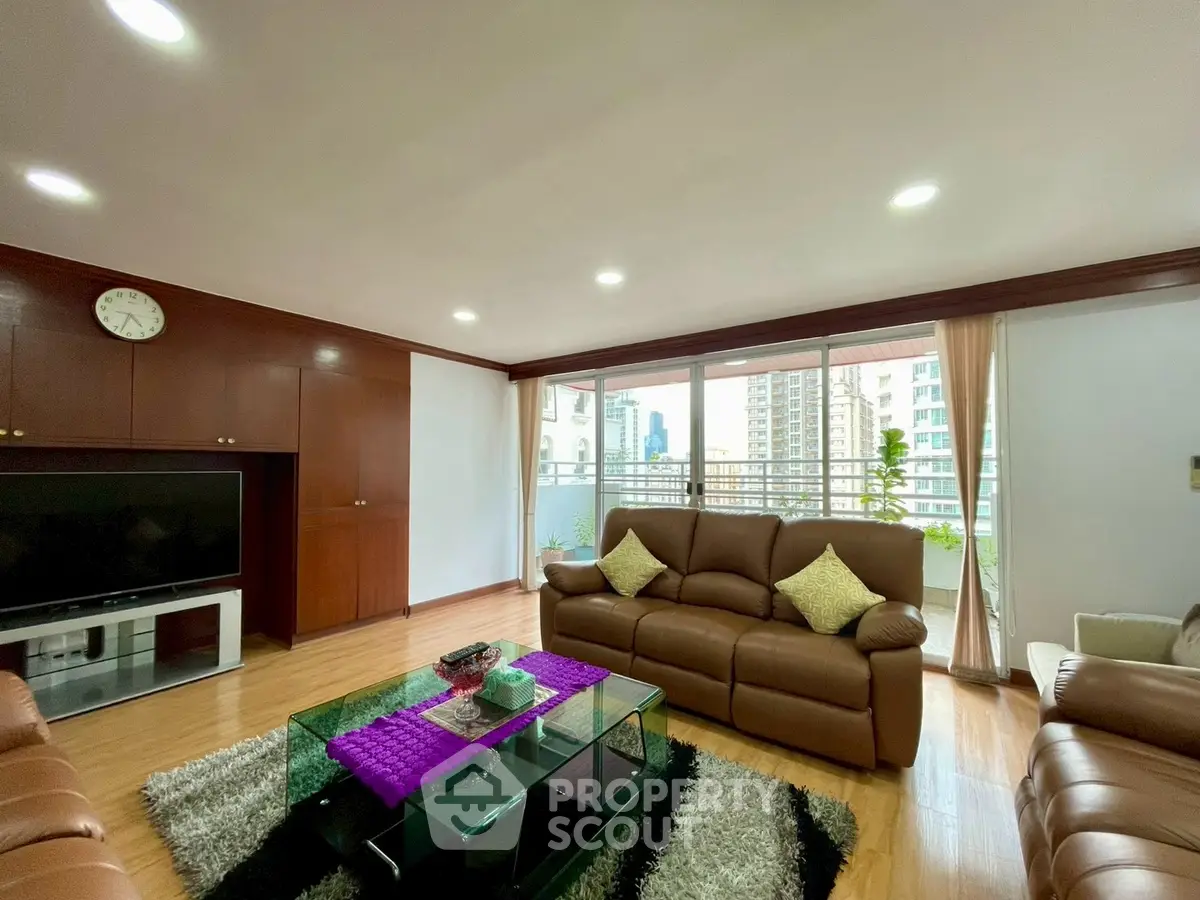 Spacious living room with leather sofas and city view balcony in modern apartment