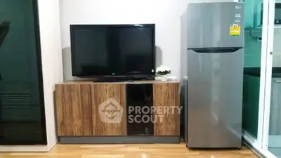 Modern living room with TV and fridge, sleek wooden cabinet, and stylish decor.