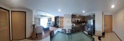 Spacious open-plan living room with modern kitchen and dining area, featuring sleek appliances and stylish decor.