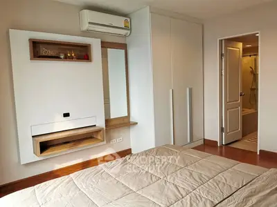 Modern bedroom with ensuite bathroom and sleek storage solutions.