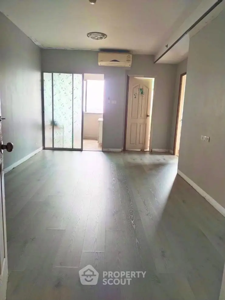 Spacious empty room with wooden flooring and natural light, ideal for customization.