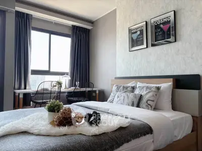 Modern bedroom with stylish decor and large window offering natural light.