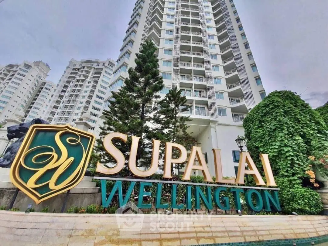 Luxurious high-rise Supalai Wellington building with lush greenery and elegant signage.