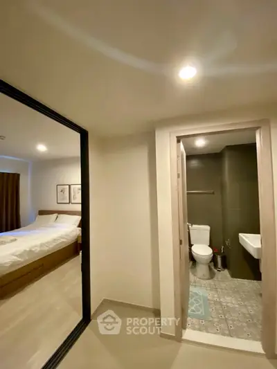 Modern apartment interior with bedroom and bathroom, featuring sleek design and cozy ambiance.