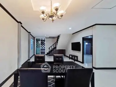 Elegant living room with modern chandelier and sleek black furniture