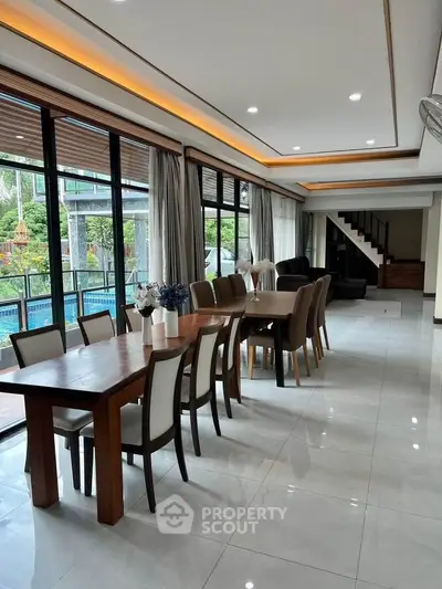 Spacious modern living room with pool view and elegant dining area