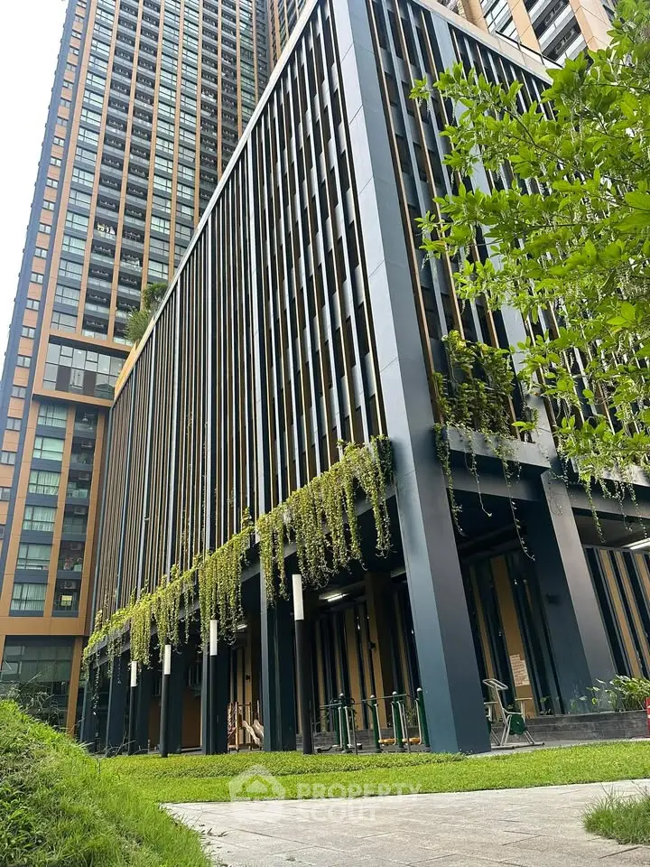 Modern high-rise building with lush greenery and sleek architectural design