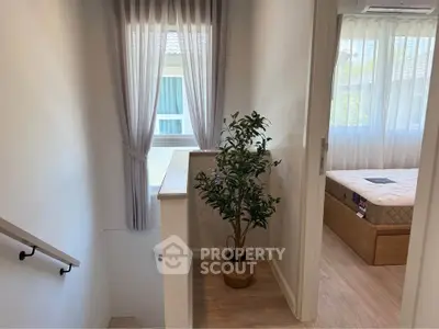 Charming interior view of a cozy home with a staircase and a sunlit bedroom, perfect for modern living.