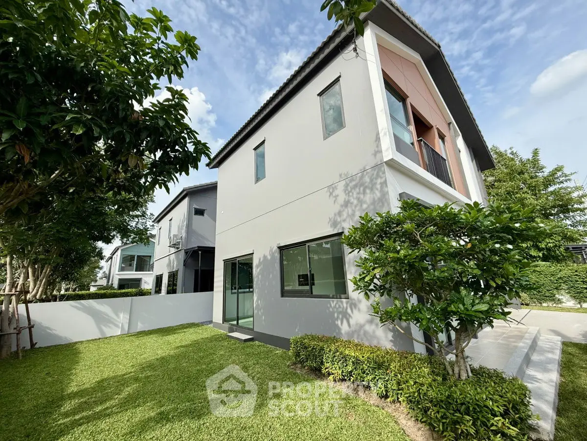 Modern two-story house with lush green lawn and contemporary design