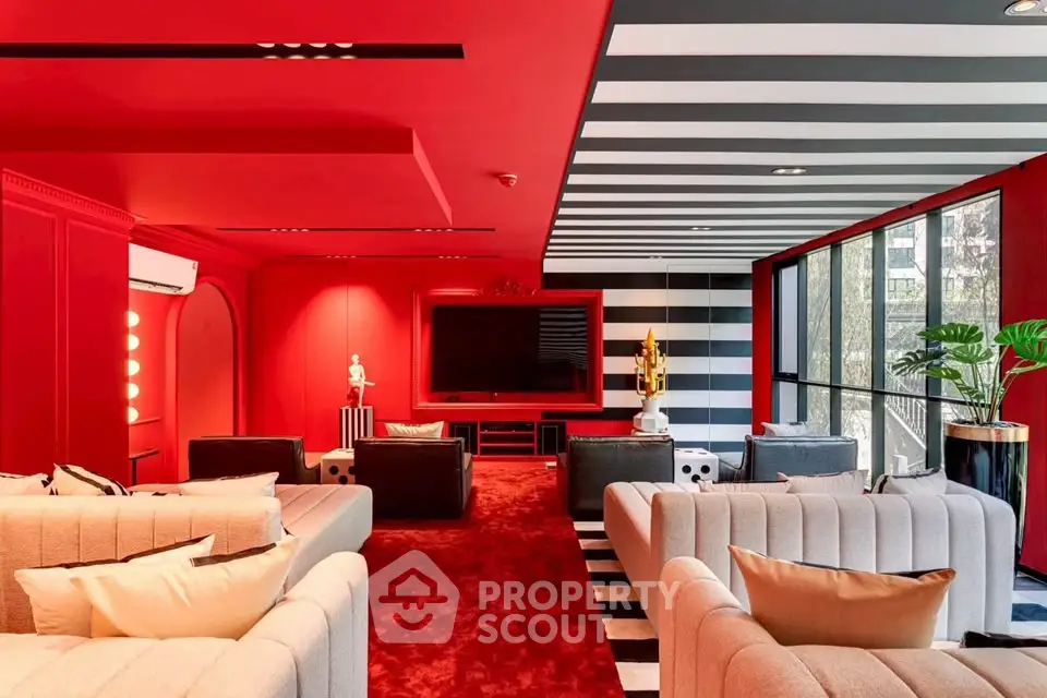Luxurious modern living room with bold red and black decor, plush seating, and large windows.