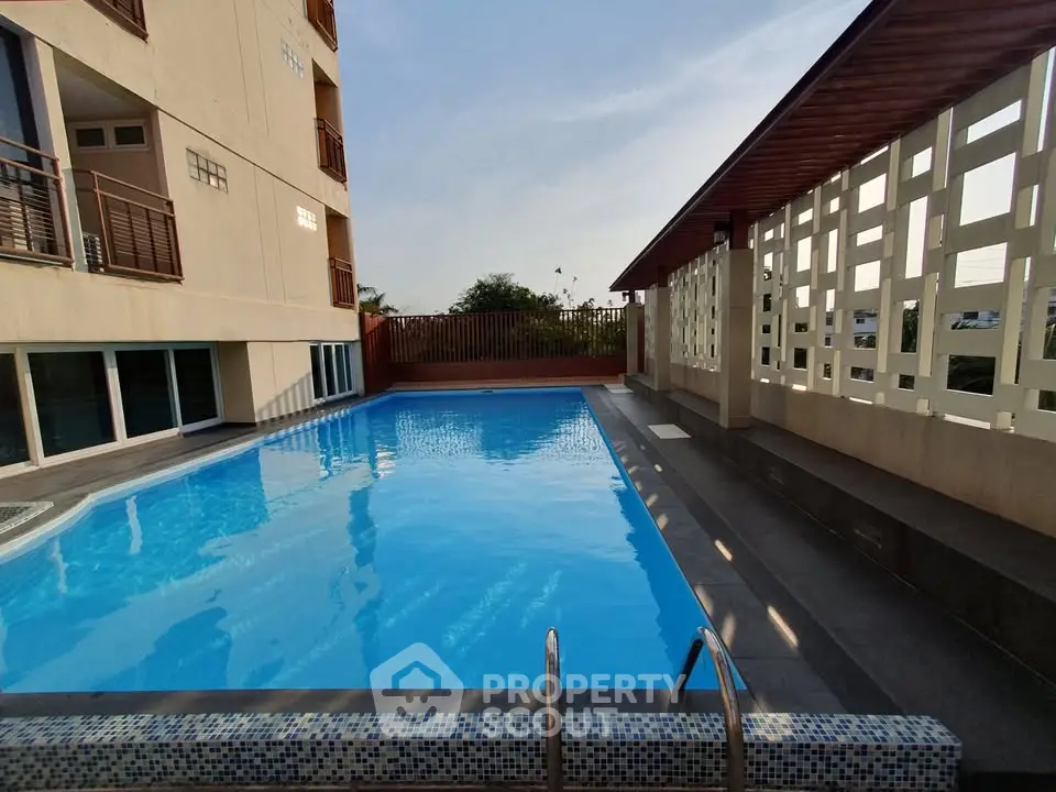 Luxurious apartment complex with a pristine swimming pool and modern design.