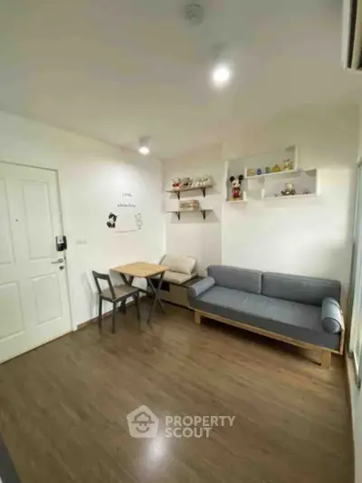 Cozy living room with modern decor and wooden flooring, featuring a stylish sofa and dining area.