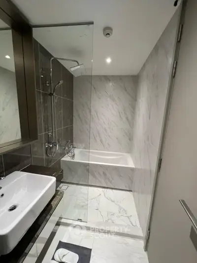 Modern bathroom with sleek design, featuring a glass-enclosed shower and elegant marble tiles.