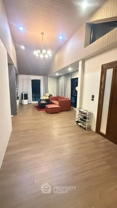 Spacious living room with high ceiling and modern decor, perfect for relaxation and entertainment.