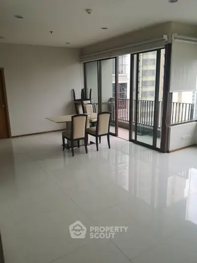 Spacious modern living room with large windows and balcony access.