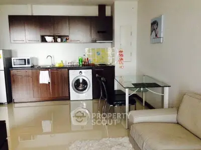 Modern open-plan kitchen with sleek cabinetry and integrated appliances in cozy living space.