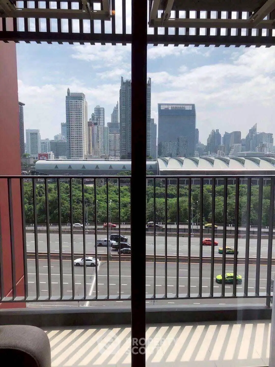 Stunning cityscape view from a modern balcony overlooking a bustling highway.