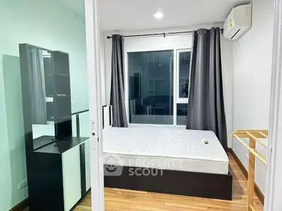 Modern bedroom with large window and sleek furniture in a stylish apartment.