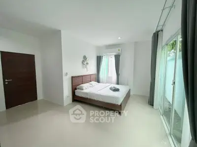 Spacious bedroom with modern decor and large windows for natural light
