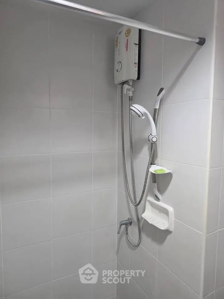 Modern bathroom with sleek shower and water heater in minimalist design.