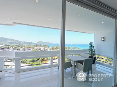 Luxurious seaside living room with panoramic ocean view, modern furniture, and seamless indoor-outdoor flow through sliding glass doors.