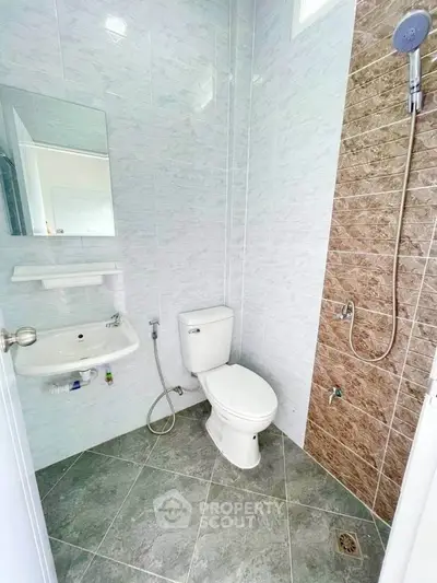 Modern bathroom with sleek tiles and shower in a real estate property.