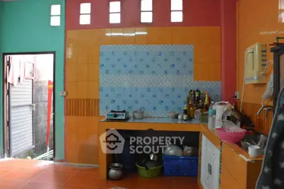 Vibrant kitchen with colorful tiles and open layout, featuring essential appliances and ample storage space.