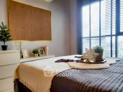 Cozy bedroom with modern decor and large window offering natural light.