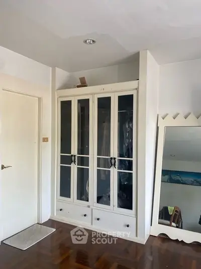 Spacious bedroom with elegant wardrobe and large mirror