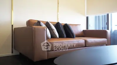 Stylish modern living room with elegant brown leather sofa and plush cushions, perfect for relaxation.