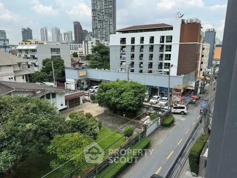 Urban cityscape view with residential and commercial buildings, showcasing vibrant city life and greenery.