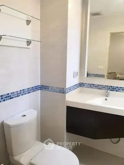 Modern bathroom with sleek fixtures and stylish blue tile accents