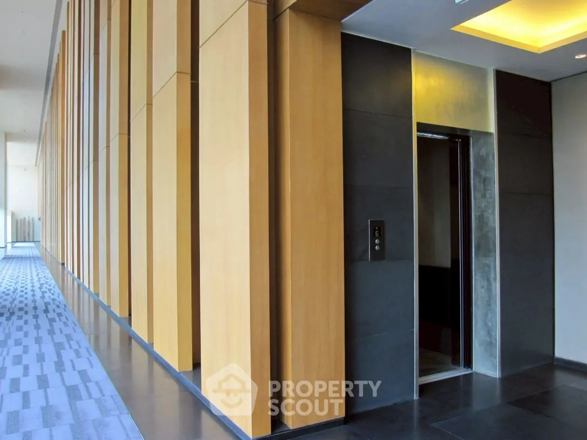 Modern elevator lobby with sleek wooden paneling and contemporary design.