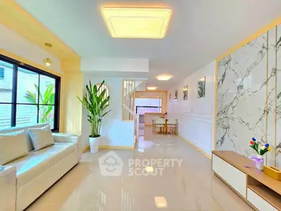 Spacious modern living room with elegant marble accents and cozy seating area.