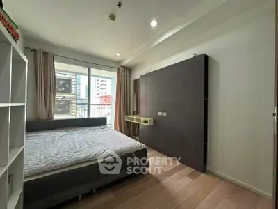 Modern bedroom with large window and stylish furnishings in urban apartment
