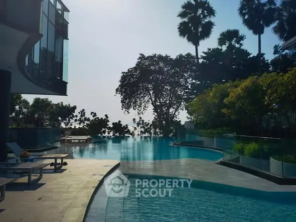 Luxurious infinity pool with stunning views and lush greenery in a modern residential complex.