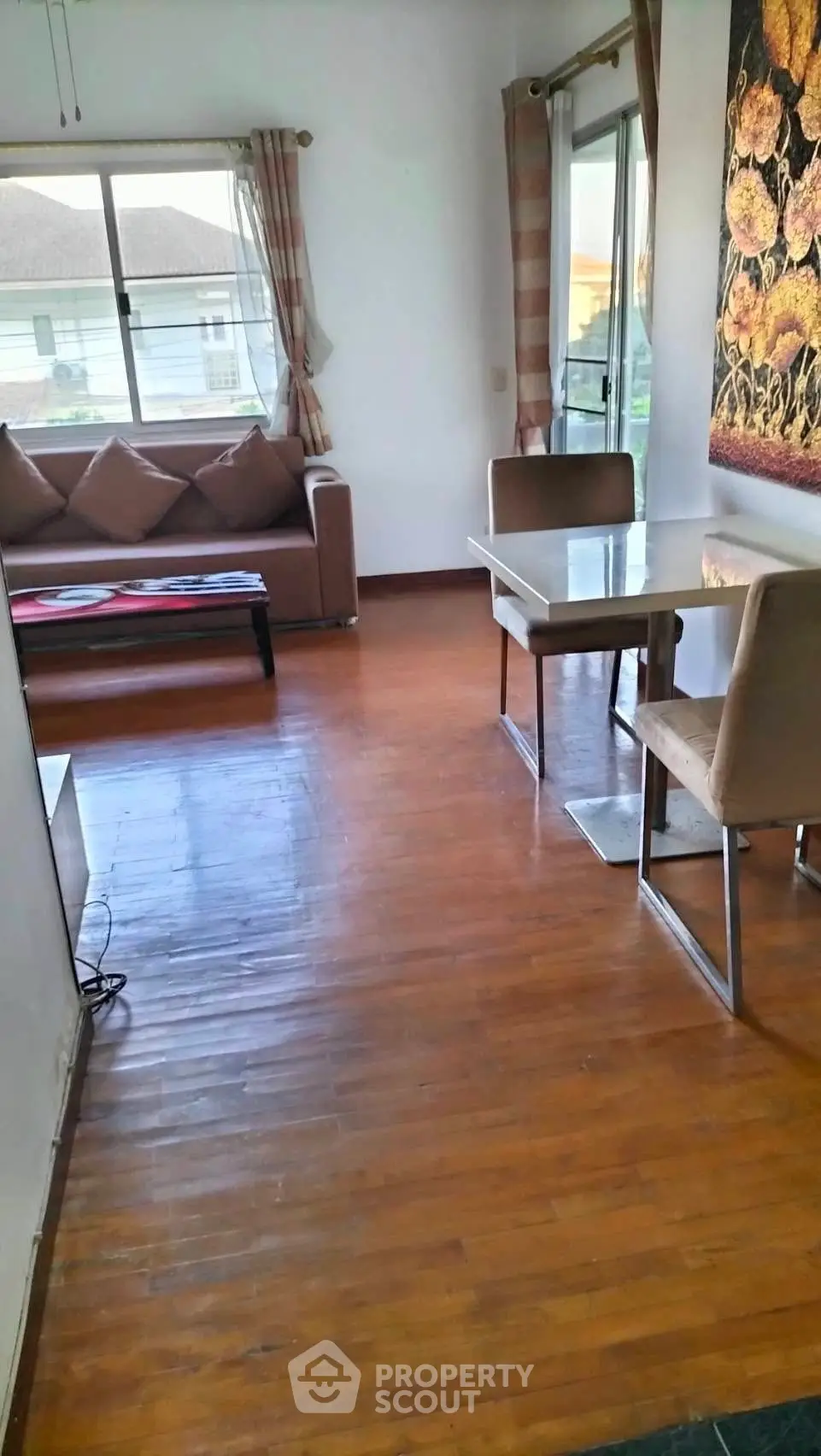 Charming living room with wooden floors and cozy seating area, perfect for relaxation.