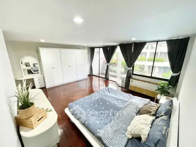 Spacious bedroom with large windows and elegant decor in modern apartment